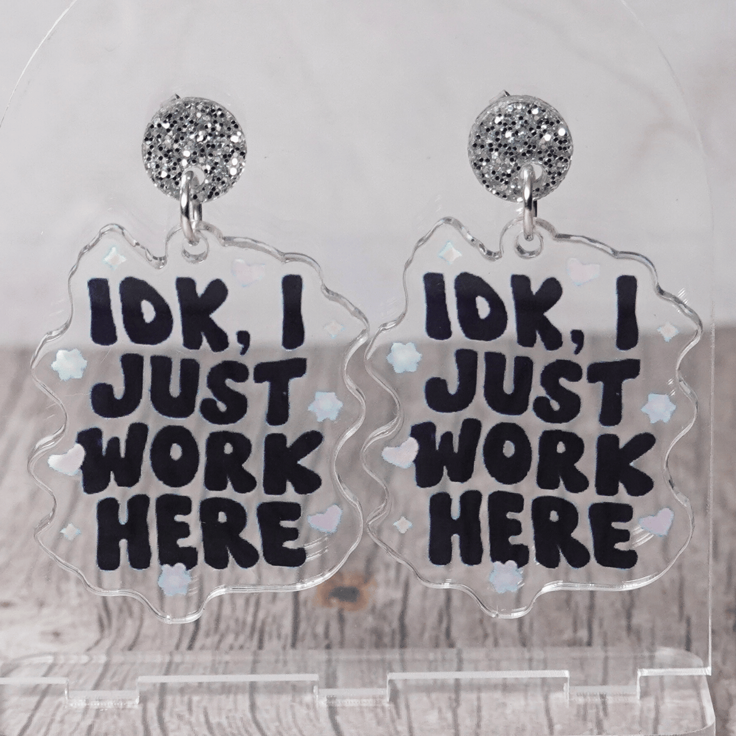 Clear acrylic dangle earrings with the phrase “IDK, I just work here” in bold black lettering