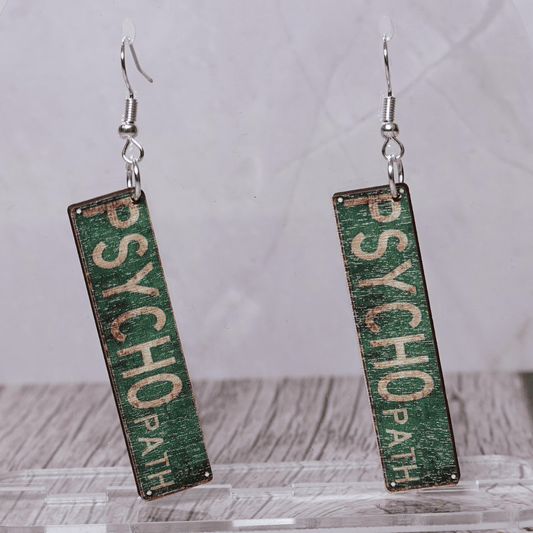 Green novelty dangle earrings shaped like a “Psychopath” street sign