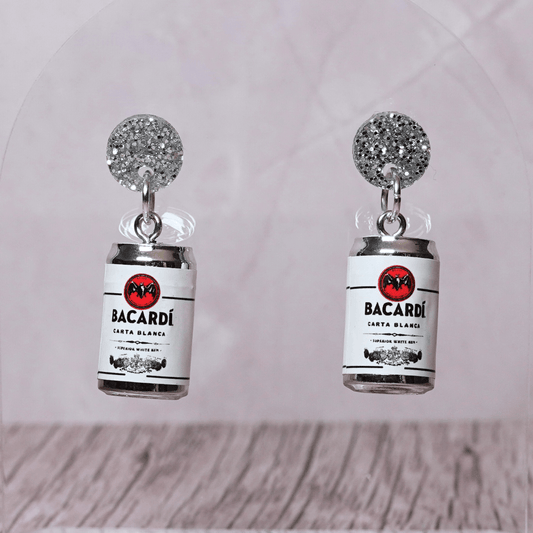 Novelty dangle earrings shaped like mini bacardi white rum cans with a printed label design and silver glitter studs.