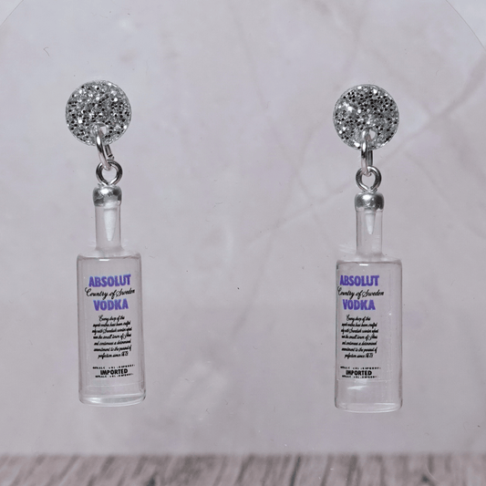Novelty dangle earrings shaped like clear vodka bottles with a printed vodka-style label design.