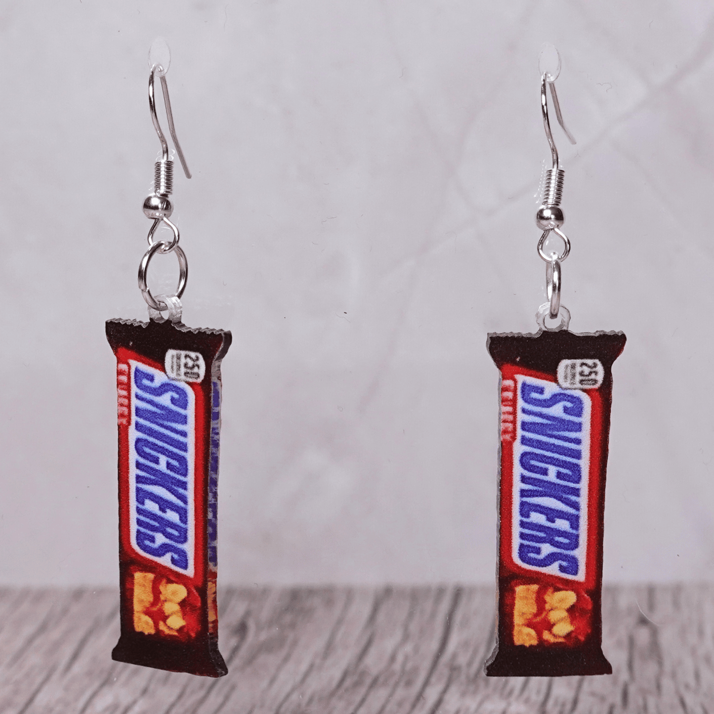 Chocolate bar shaped dangle earrings styled like a wrapped candy bar on silver hooks.