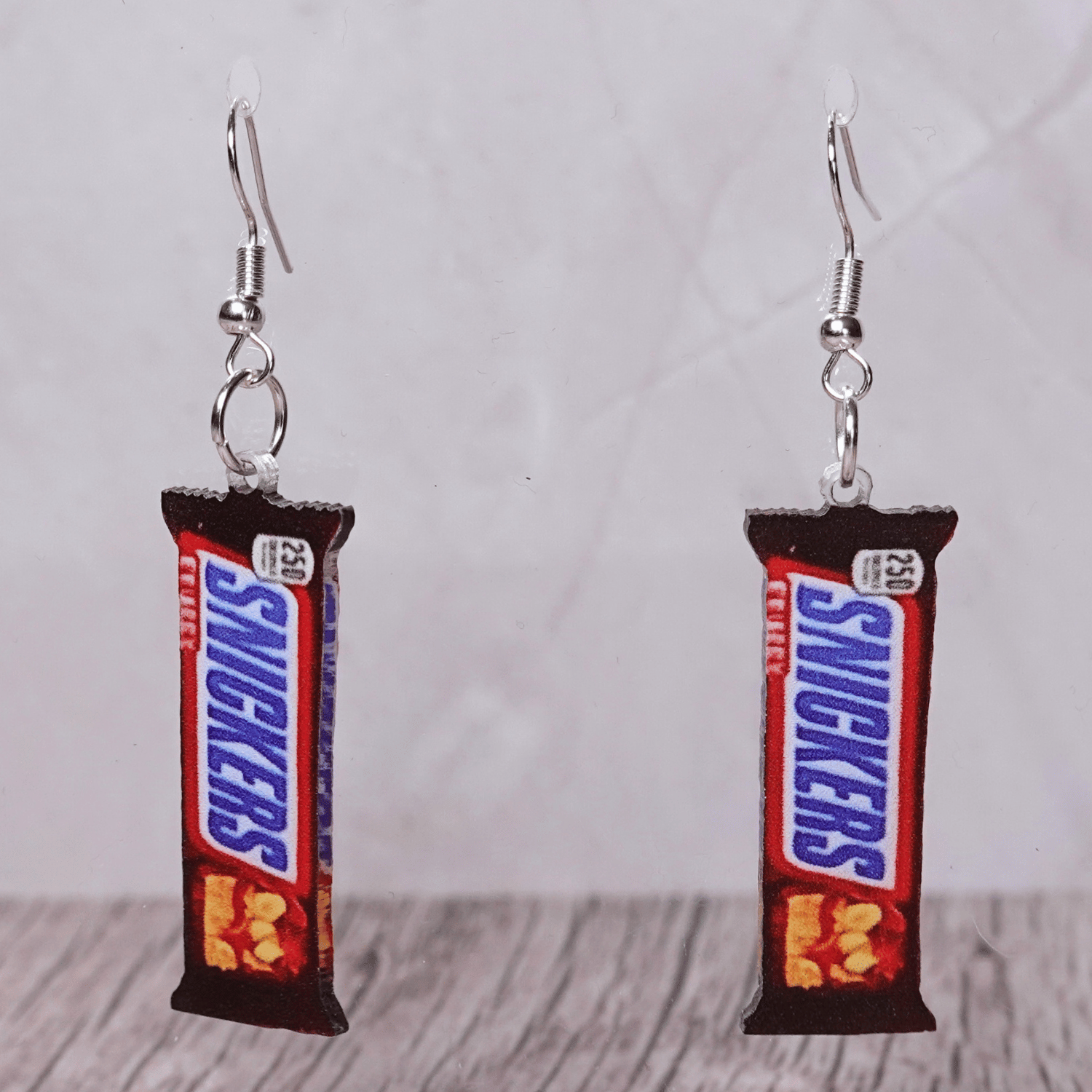 Chocolate bar shaped dangle earrings styled like a wrapped candy bar on silver hooks.