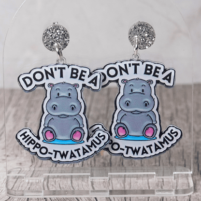 Novelty dangle earrings with a cute cartoon hippo and the phrase “Don’t be a hippo-twatamus”