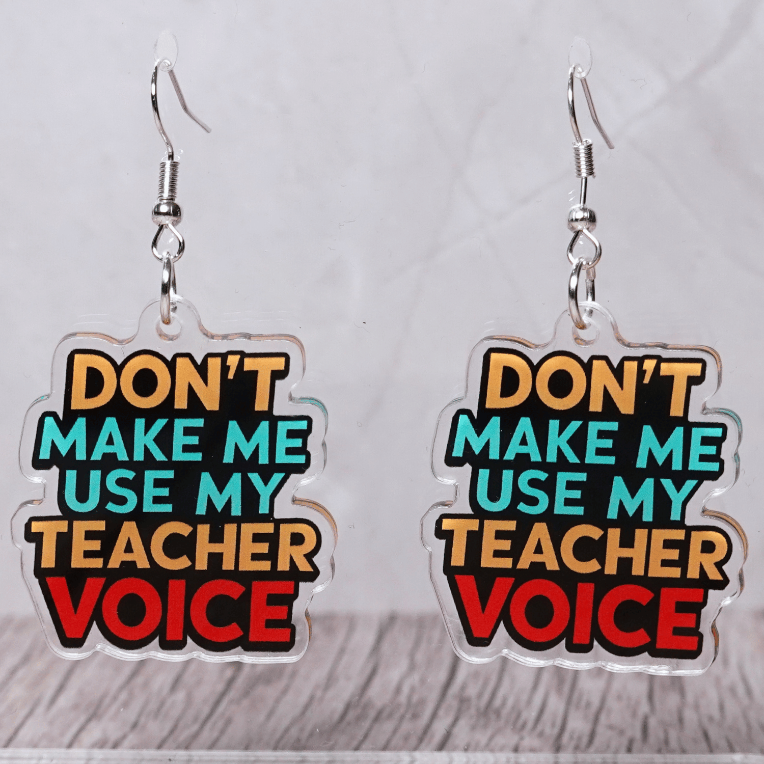 Colorful novelty dangle earrings with text “don’t make me use my teacher voice”
