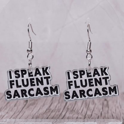 Black and white novelty earrings reading “I speak fluent sarcasm”