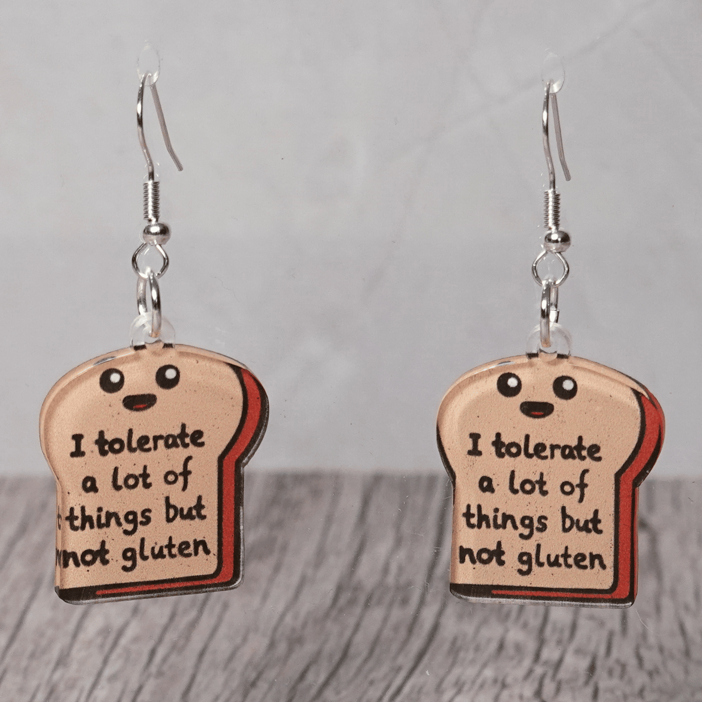 Acrylic dangle earrings shaped like a slice of bread with text reading “I tolerate a lot of things but not gluten”