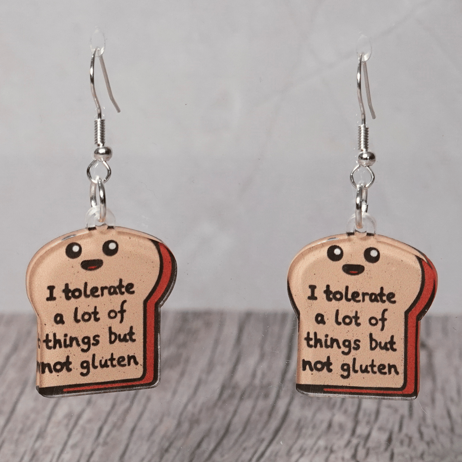 Acrylic dangle earrings shaped like a slice of bread with text reading “I tolerate a lot of things but not gluten”