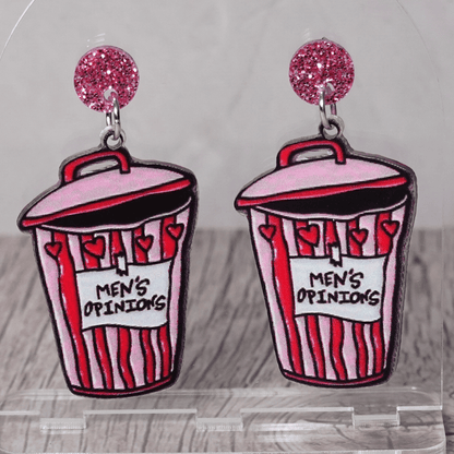 Acrylic dangle earrings shaped like a pink and red trash can labeled “Men’s Opinions”