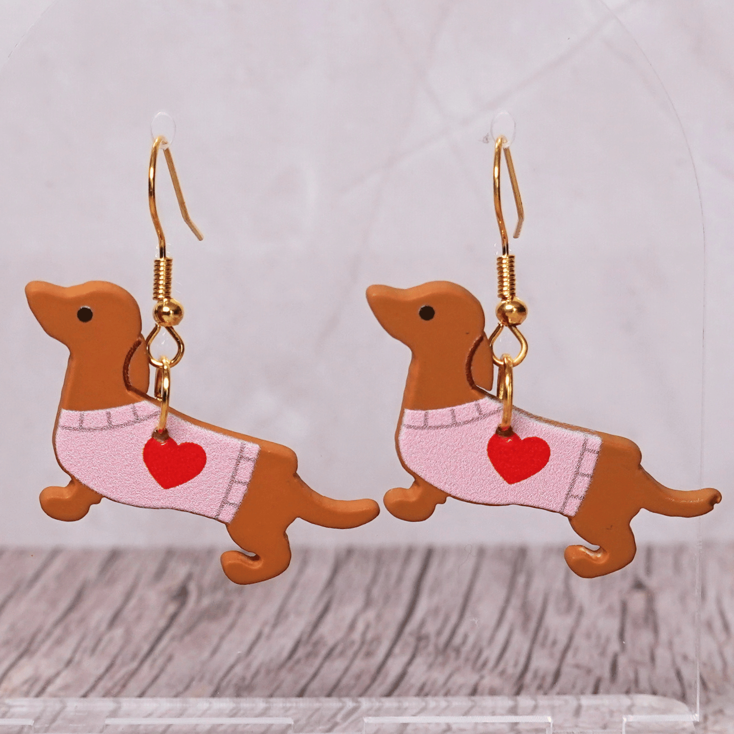 Dachshund dangle earrings featuring brown sausage dogs wearing heart sweaters