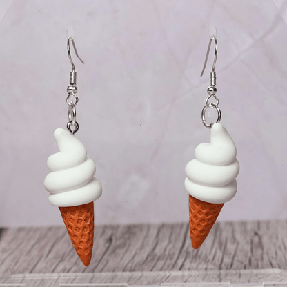 Cute dangle earrings shaped like soft serve vanilla ice cream in waffle cones.