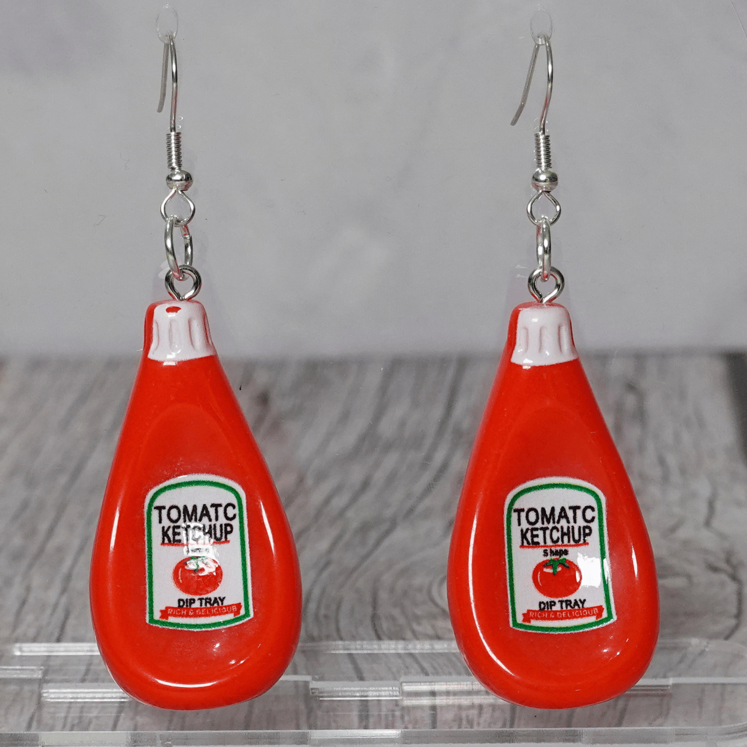 Red tomato ketchup bottle shaped dangle earrings with white cap and silver hooks.