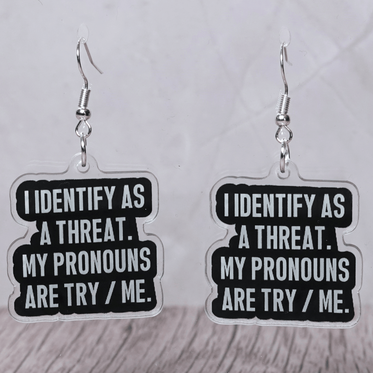 Black and white novelty earrings reading I identify as a threat my pronouns are try me
