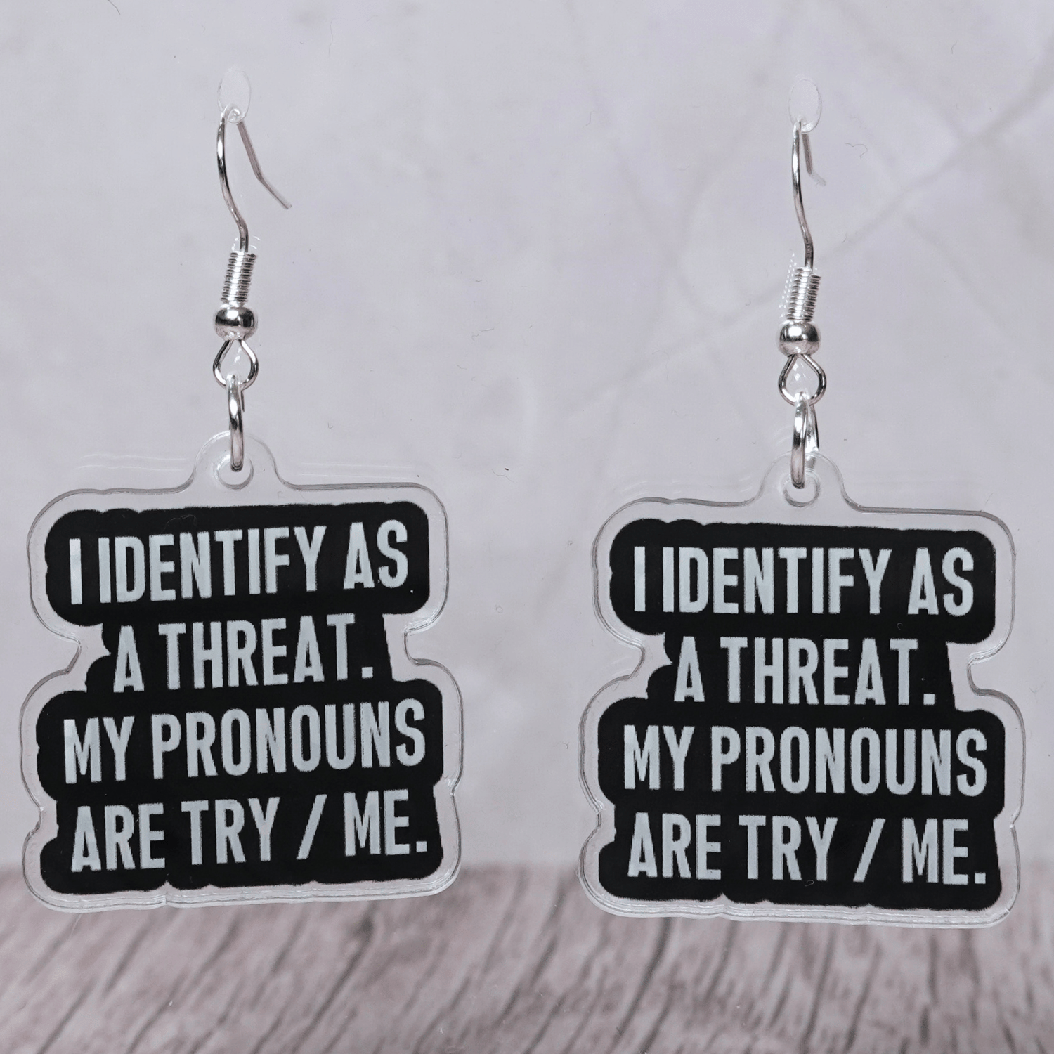 Black and white novelty earrings reading I identify as a threat my pronouns are try me