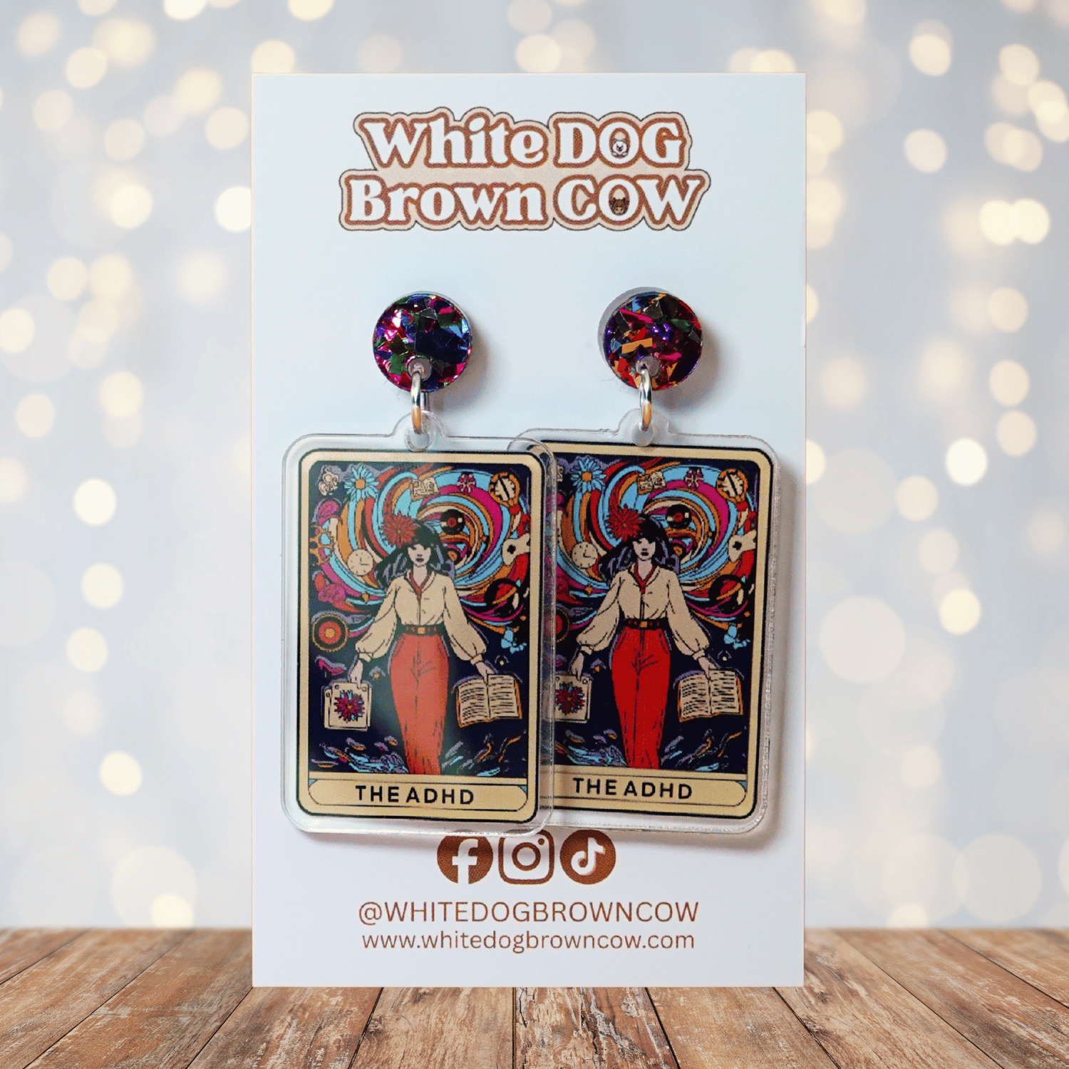 Acrylic dangle earrings featuring a colorful tarot-style card labeled “The ADHD” with a woman surrounded by swirling patterns and books.