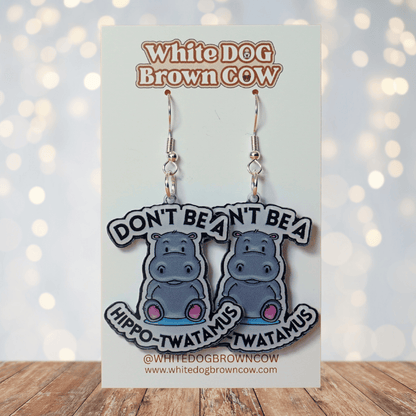 Novelty dangle earrings with a cute cartoon hippo and the phrase “Don’t be a hippo-twatamus”