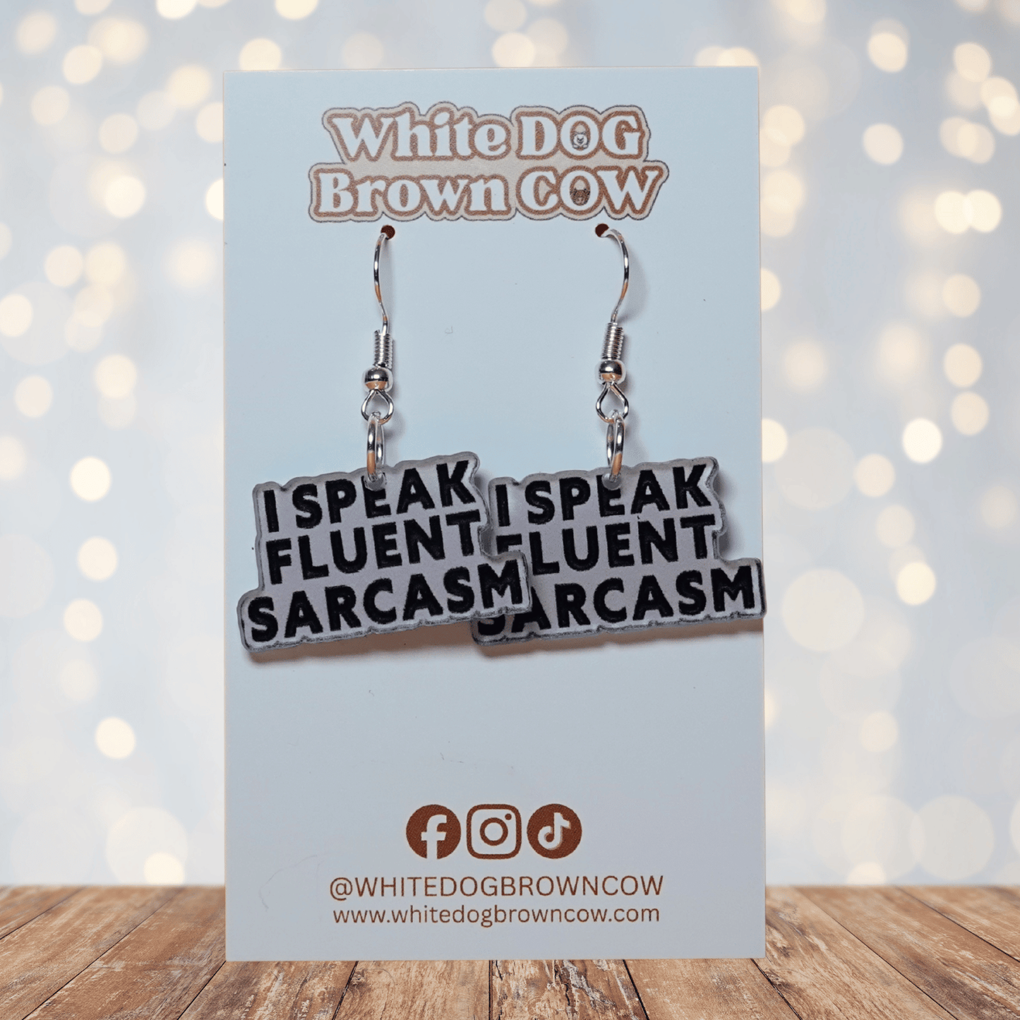 Black and white novelty earrings reading “I speak fluent sarcasm”