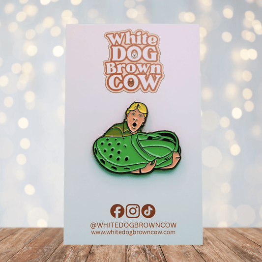 Funny enamel pin of Steve Irwin holding a giant green croc shoe, humorous novelty pin