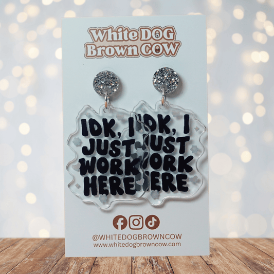 Clear acrylic dangle earrings with the phrase “IDK, I just work here” in bold black lettering