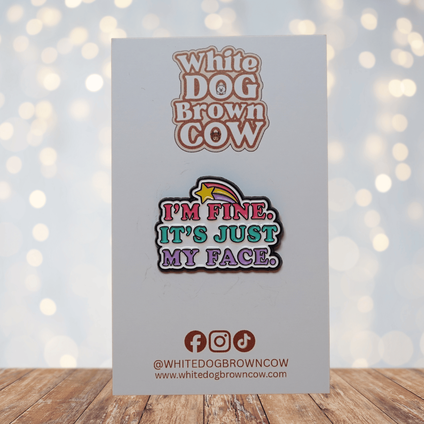 Colorful enamel pin reading “I’m Fine, It’s Just My Face” with retro pink, teal and purple lettering and shooting star detail, funny sarcastic lapel pin.