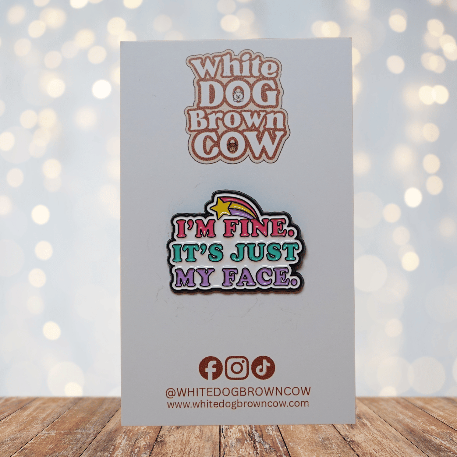 Colorful enamel pin reading “I’m Fine, It’s Just My Face” with retro pink, teal and purple lettering and shooting star detail, funny sarcastic lapel pin.