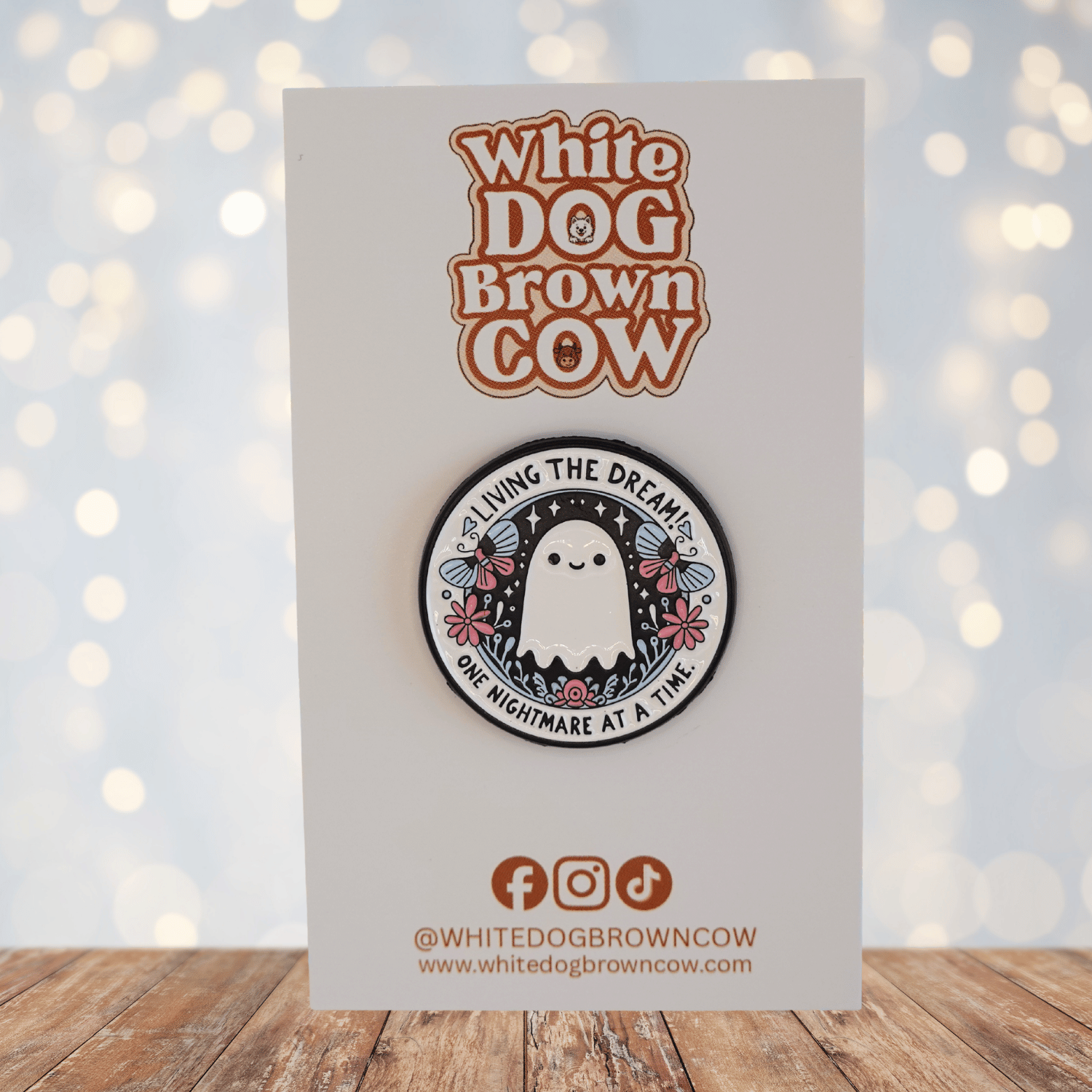 Cute ghost enamel pin with flowers and text “living the dream one nightmare at a time,” funny sarcastic spooky pin