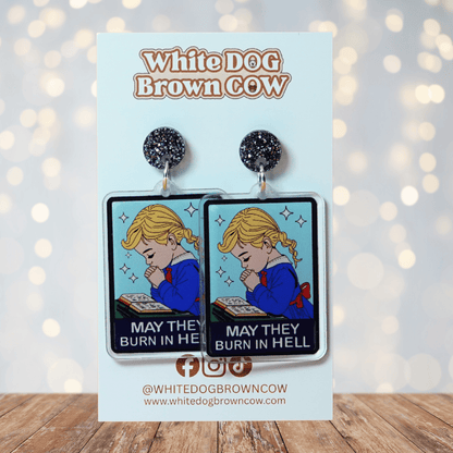 Clear acrylic dangle earrings with a vintage illustration of a praying girl and text reading “May they burn in hell”