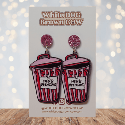 Acrylic dangle earrings shaped like a pink and red trash can labeled “Men’s Opinions”
