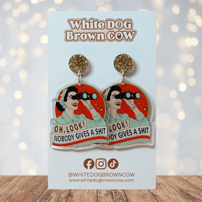 Retro style novelty dangle earrings showing a woman with binoculars and the phrase “Oh look nobody gives a sh*t”