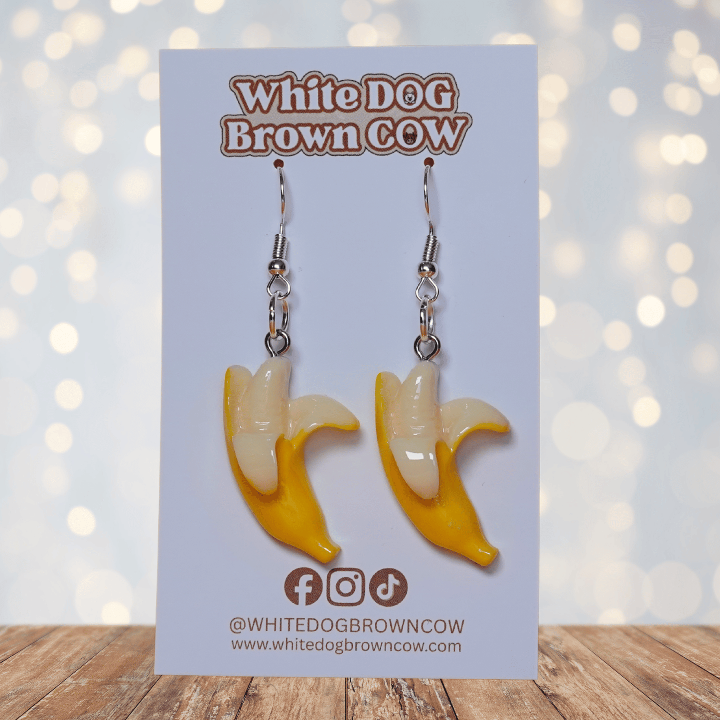 Cute dangle earrings shaped like partially peeled bananas with a realistic yellow and cream design.
