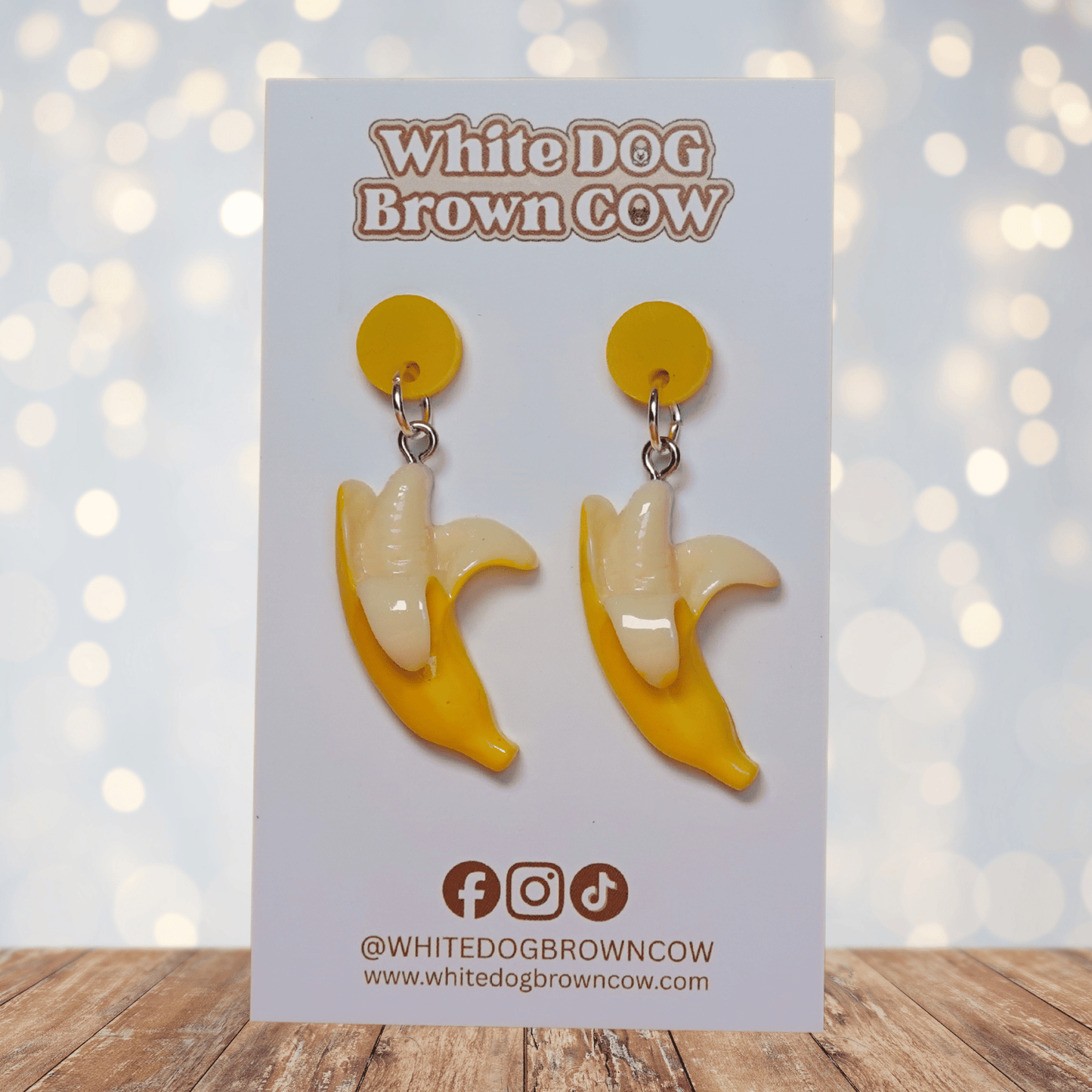 Cute dangle earrings shaped like partially peeled bananas with a realistic yellow and cream design.