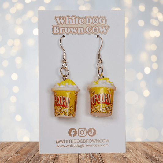 Yellow popcorn bucket shaped dangle earrings filled with popcorn and silver hooks.