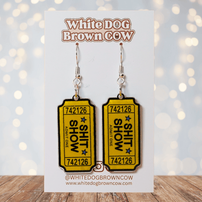 Acrylic dangle earrings designed like yellow admit-one tickets reading “Shit Show”