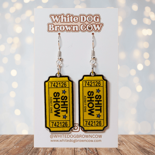 Acrylic dangle earrings designed like yellow admit-one tickets reading “Shit Show”