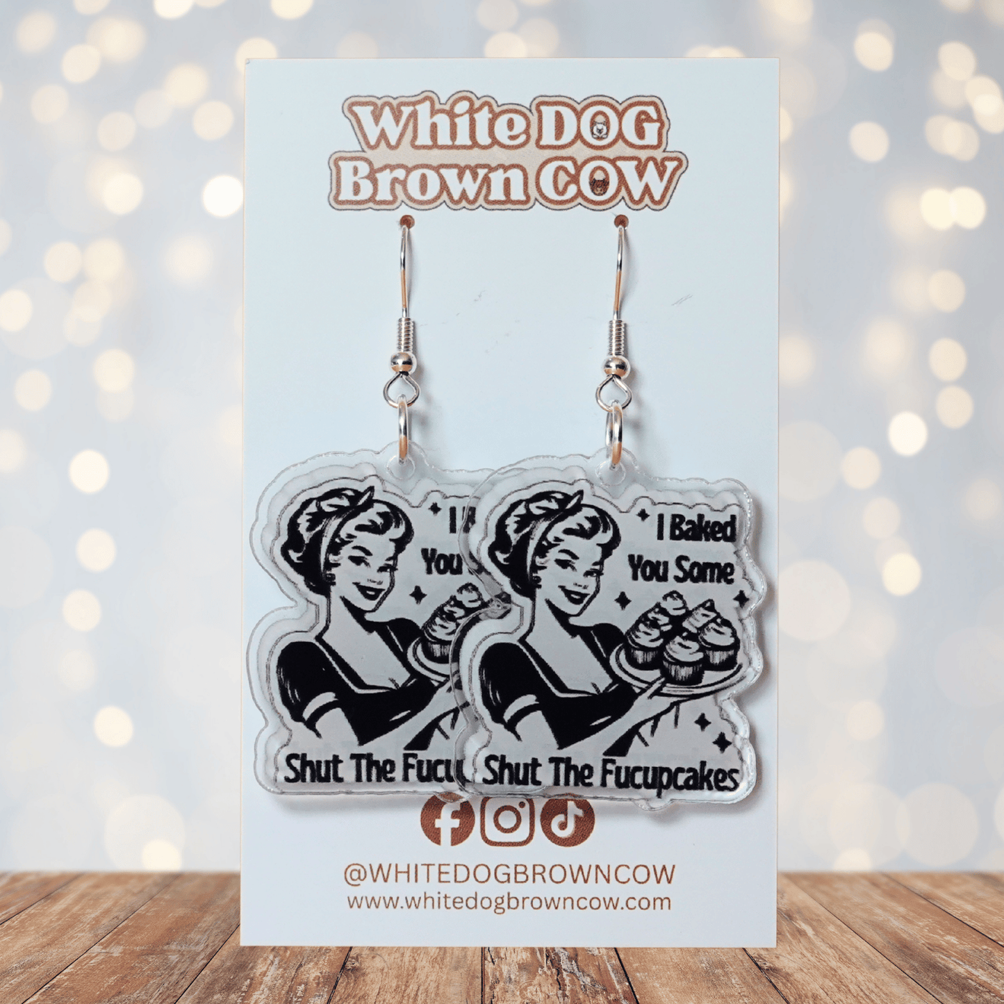 Retro style novelty dangle earrings with a vintage woman holding cupcakes and the phrase “I baked you some shut the fucupcakes”
