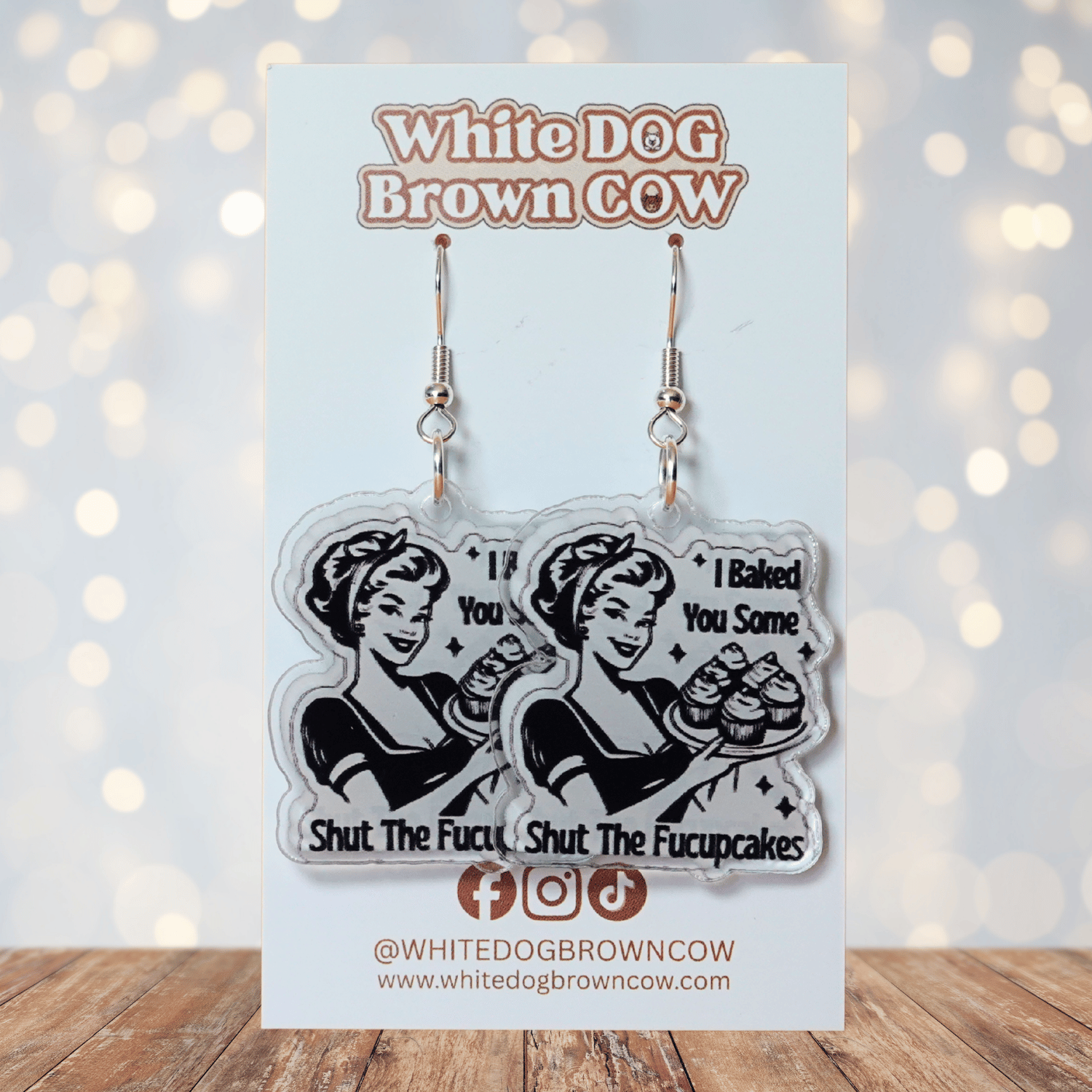 Retro style novelty dangle earrings with a vintage woman holding cupcakes and the phrase “I baked you some shut the fucupcakes”