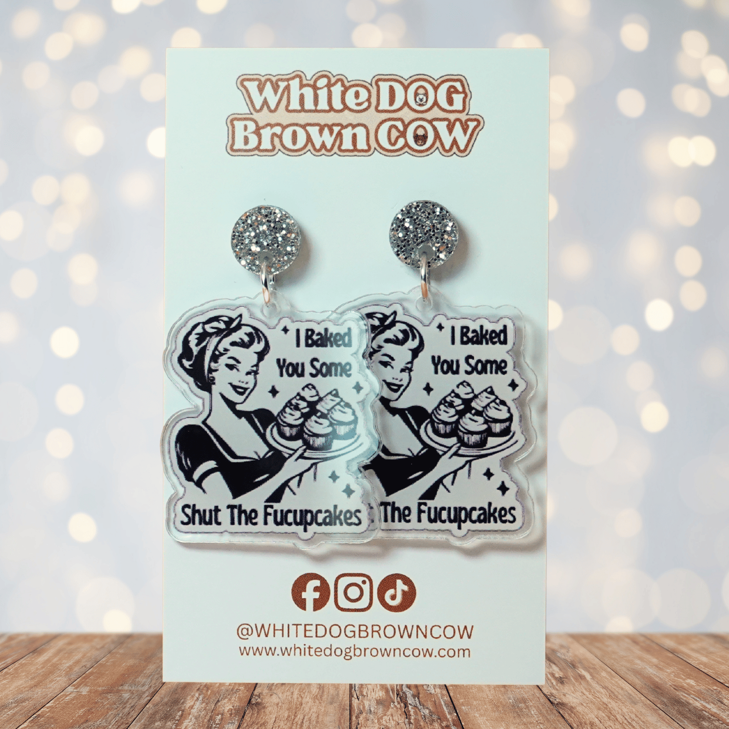 Retro style novelty dangle earrings with a vintage woman holding cupcakes and the phrase “I baked you some shut the fucupcakes”