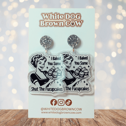 Retro style novelty dangle earrings with a vintage woman holding cupcakes and the phrase “I baked you some shut the fucupcakes”