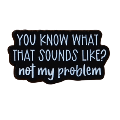 Black and white enamel pin reading “You Know What That Sounds Like? Not My Problem” in bold lettering, funny sarcastic office humor lapel pin.